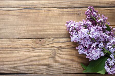 branch of purple lilac on a wooden background. Spring flowers on a wooden background with a place under the inscription.の写真素材