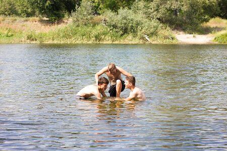 Jumping in the water. Kids have fun and splash in the water. Summer holiday concept , three friends are having fun on the riverの写真素材