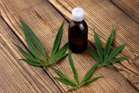 hemp oil on a wooden background. Marijuana branches on an old background. The concept of alternative treatmentの写真素材