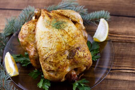 Baked chicken on wooden background. Festive lunch for the holidays. Cooked chicken at homeの写真素材