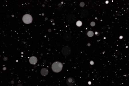 Freeze motion of white powder coming down, isolated on black, dark background. Abstract design of falling dust cloud. Particles cloud screen saver, wallpaper with copy space. Rain, snow fall conceptの写真素材