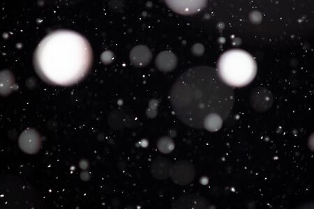 Freeze motion of white powder coming down, isolated on black, dark background. Abstract design of falling dust cloud. Particles cloud screen saver, wallpaper with copy space. Rain, snow fall conceptの写真素材