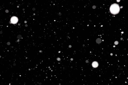 Freeze motion of white powder coming down, isolated on black, dark background. Abstract design of falling dust cloud. Particles cloud screen saver, wallpaper with copy space. Rain, snow fall conceptの写真素材