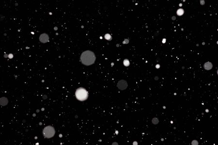 Freeze motion of white powder coming down, isolated on black, dark background. Abstract design of falling dust cloud. Particles cloud screen saver, wallpaper with copy space. Rain, snow fall conceptの写真素材