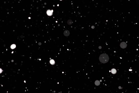 Freeze motion of white powder coming down, isolated on black, dark background. Abstract design of falling dust cloud. Particles cloud screen saver, wallpaper with copy space. Rain, snow fall conceptの写真素材