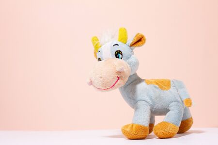 a cow toy on a pink pastel background with a copy of the space. Children's toyの写真素材