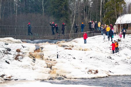 Saint Petersburg. RUSSIA . January 2, 2020. a group of tourists walk on a pedestrian bridge in nature in the winter . Hiking in coniferous forests. Group nature walkの写真素材
