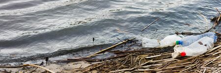 ocean rubbish banner. Polluted coastline, with place for an inscription. Panoramic view of the riverbank polluted with plastic wasteの写真素材