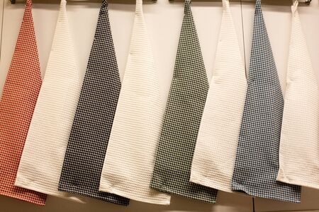 texture of multi-colored kitchen towels hanging on a hanger, closeup. Set of rags in the kitchenの写真素材