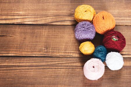 group of multi-colored woolen clews with crochet for embroidery on a wooden background with copy space. Home Designer Sewingの写真素材