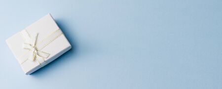 small gift on a pastel background, closeup. Gift box with a bow. copy space, banner photo