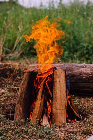 burning campfire outdoors in the shape of a hut, close-up. Camping in the wildの写真素材