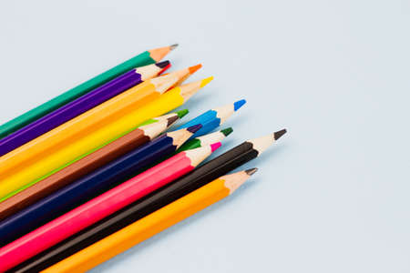 Bright colored assorted pencils on a light blue background. View from above. Place for text.の写真素材
