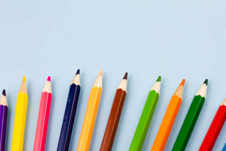 Colored colorful pencils on a light blue background. Place for your text. View from above. Education concept.の写真素材