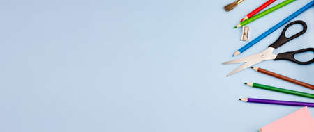 All kinds of colorful school supplies on a blue background. Banner. Place for text. View from above.の写真素材
