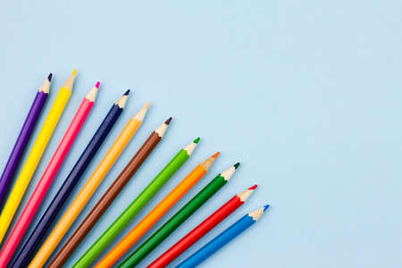 Colored colorful pencils on a light blue background. Place for your text. View from above. Education concept.の写真素材