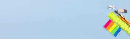 Bright multicolored school supplies for study on a blue background. Banner photo. Place for your text. View from above. Education concept.の写真素材
