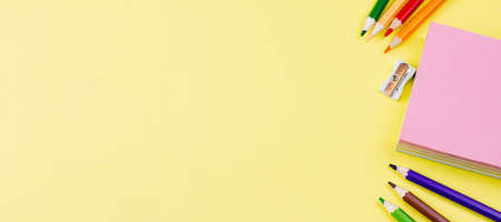 Notes with colored pencils on a yellow background. Banner photo. Place for your text. View from above. Education concept.の写真素材