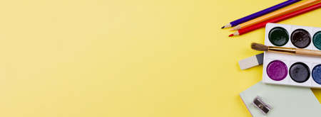 All sorts of colorful school supplies on a yellow background. Photo banner. Place for your text. View from above.の写真素材