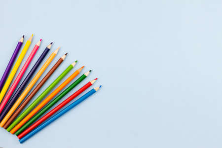 Colored colorful pencils on a light blue background. Place for your text. View from above. Education concept.の写真素材
