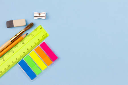 Bright various school supplies on a blue background. View from above. Place for your text. Education...