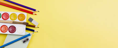 All sorts of colorful school supplies on a yellow background. Photo banner. Place for your text. View from above.の写真素材