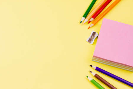 Notes with colored pencils on a yellow background. Place for your text. View from above. Education concept.の写真素材