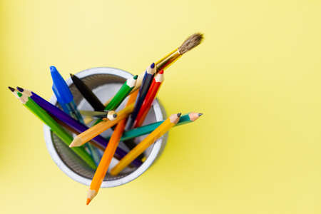 Stand with colored pencils on a yellow background. Place for your text. View from above. Education concept.の写真素材