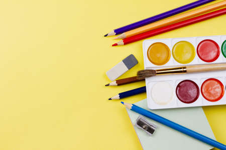 Colored bright supplies for painting on a yellow background. Place for your text. View from above. Education concept.の写真素材