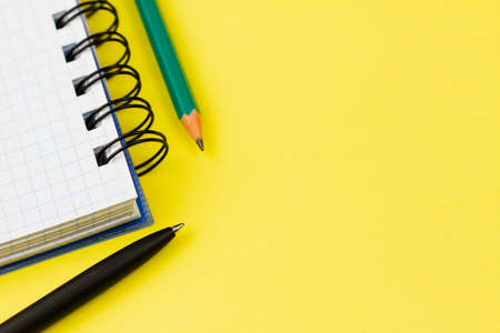 Blank white notebook with a black pen and pencil on a yellow background. View from above. Place for your text.の写真素材