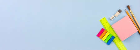 Various multicolored office supplies on a blue background. Photo banner. Place for your text. View from above.の写真素材