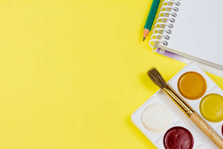 Watercolor with notepad on a yellow background. Place for your text. View from above. Education concept.の写真素材