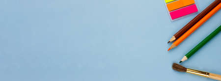 Colored pencils and notes on a blue background. Photo banner. Place for your text. Education concept.の写真素材