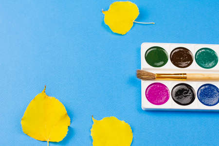 Watercolor paints on an autumn blue background. Place for your text. Photo concept. View from above.の写真素材