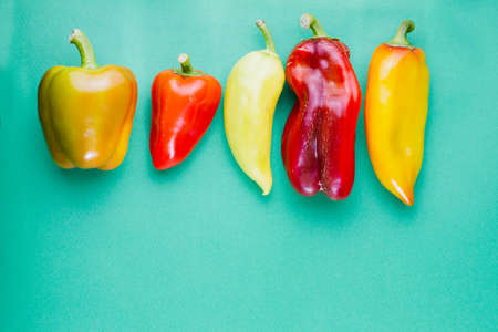 group of ripe multi-colored bell peppers on a pastel green background. Fresh vegetable food conceptの写真素材