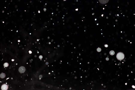 Freeze motion of white powder coming down, isolated on black, dark background. Abstract design of falling dust cloud. Particles cloud screen saver, wallpaper with copy space. Rain, snow fall conceptの写真素材