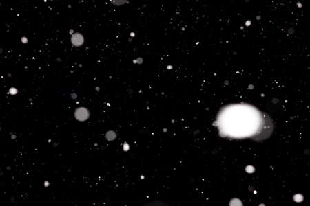 Freeze motion of white powder coming down, isolated on black, dark background. Abstract design of falling dust cloud. Particles cloud screen saver, wallpaper with copy space. Rain, snow fall conceptの写真素材