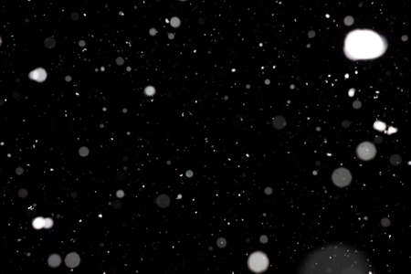 Freeze motion of white powder coming down, isolated on black, dark background. Abstract design of falling dust cloud. Particles cloud screen saver, wallpaper with copy space. Rain, snow fall conceptの写真素材