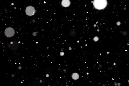 Freeze motion of white powder coming down, isolated on black, dark background. Abstract design of falling dust cloud. Particles cloud screen saver, wallpaper with copy space. Rain, snow fall conceptの写真素材