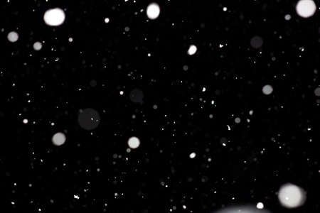 Freeze motion of white powder coming down, isolated on black, dark background. Abstract design of falling dust cloud. Particles cloud screen saver, wallpaper with copy space. Rain, snow fall conceptの写真素材
