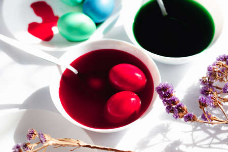 Painted eggs in a white t-shirt top view on a white table, preparation for the pasal spring celebration of spring.の写真素材