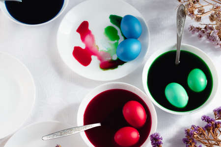 top view of easter table with plates and paints for eggs. Coloring eggs for spring holiday easter, colorful eggsの写真素材