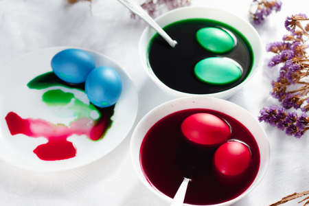 top view of easter table with plates and paints for eggs. Coloring eggs for spring holiday easter, colorful eggsの写真素材