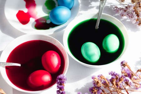 top view of easter table with plates and paints for eggs. Coloring eggs for spring holiday easter, colorful eggsの写真素材