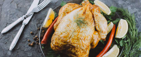 Roasted turkey or chicken. The Christmas table is served with a turkey decorated with bright tinsel. Fried chicken. table setting. Christmas dinner. Photo banner. top view on wooden backgroundの写真素材