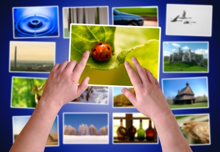 Hands choosing photos on virtual desktop の写真素材
