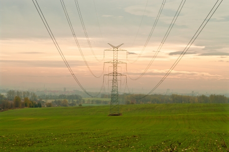 High voltage pylons and power lines to the cityの写真素材