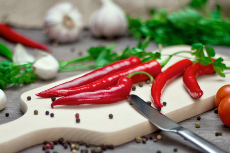 red chili peppers and spices on cutting board.
