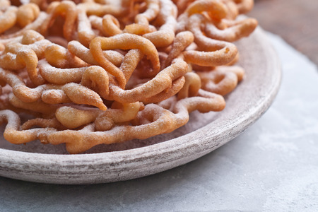 sweet crisp pastry deep fried and sprinkled with powdered sugar.