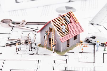 Tiny people build houses for architectural plans. The concept of teamwork.の写真素材